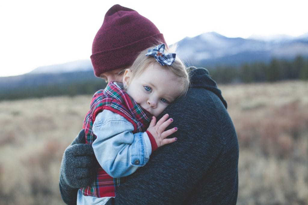 A Parent hugs their child.