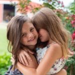 Two young girls hugging.