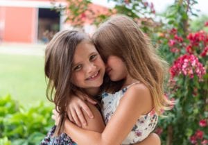 Two young girls hugging.